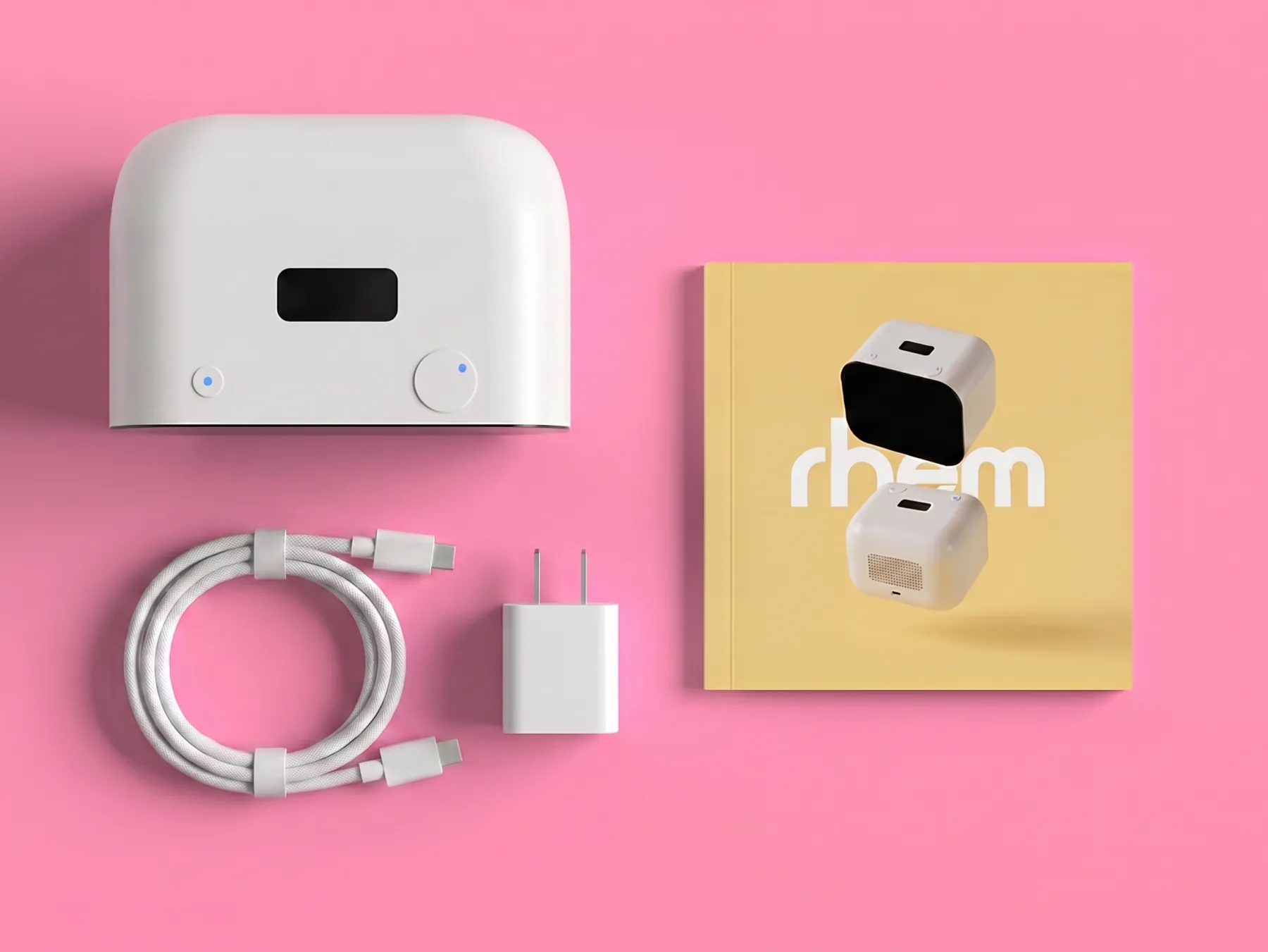 Everything in the Rhem box laid out flat: the Rhem robot, USB-C charging cable, power adapter, and welcome guide