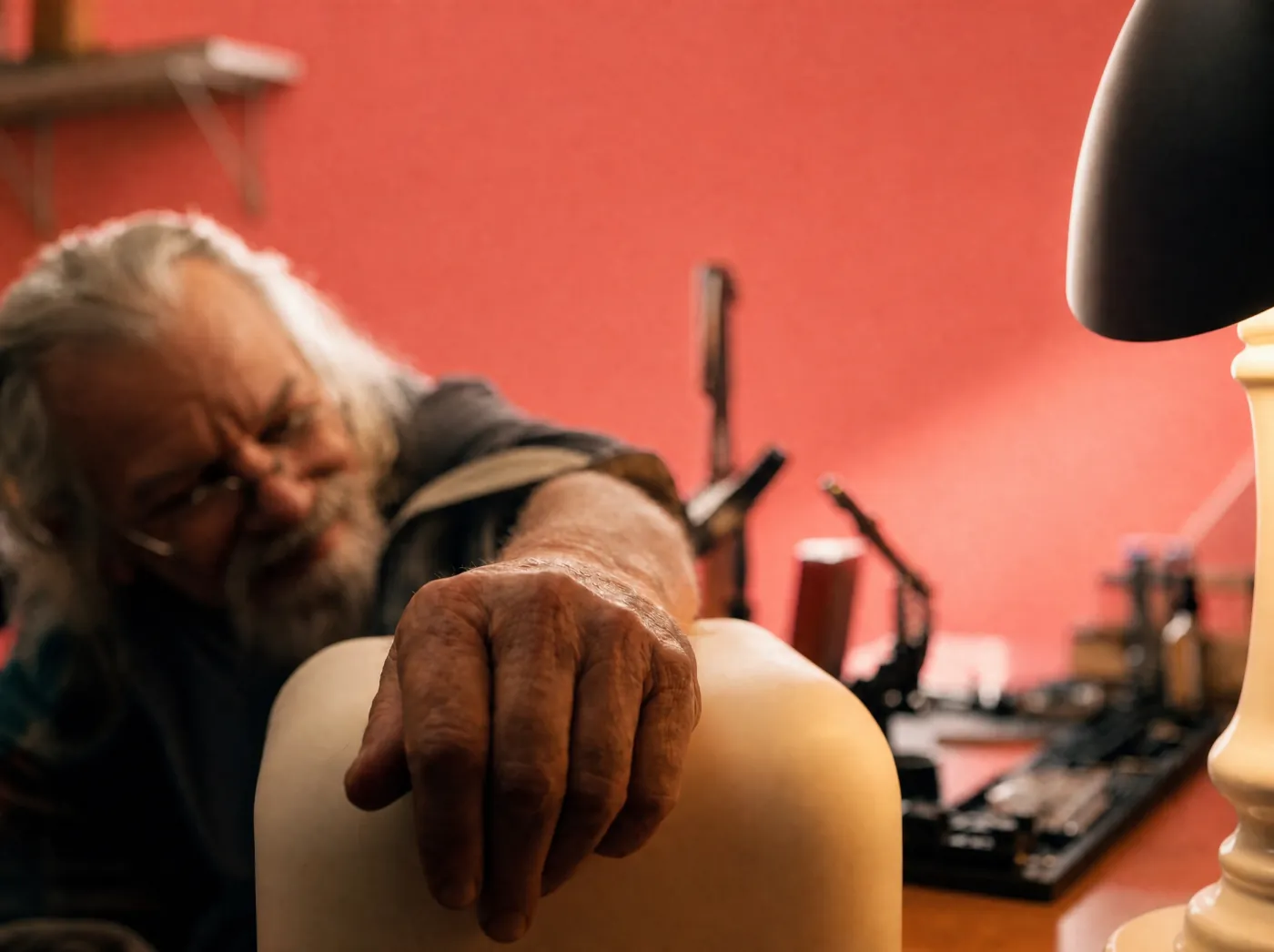 Un hombre mayor apoya la mano sobre Rhem en su taller